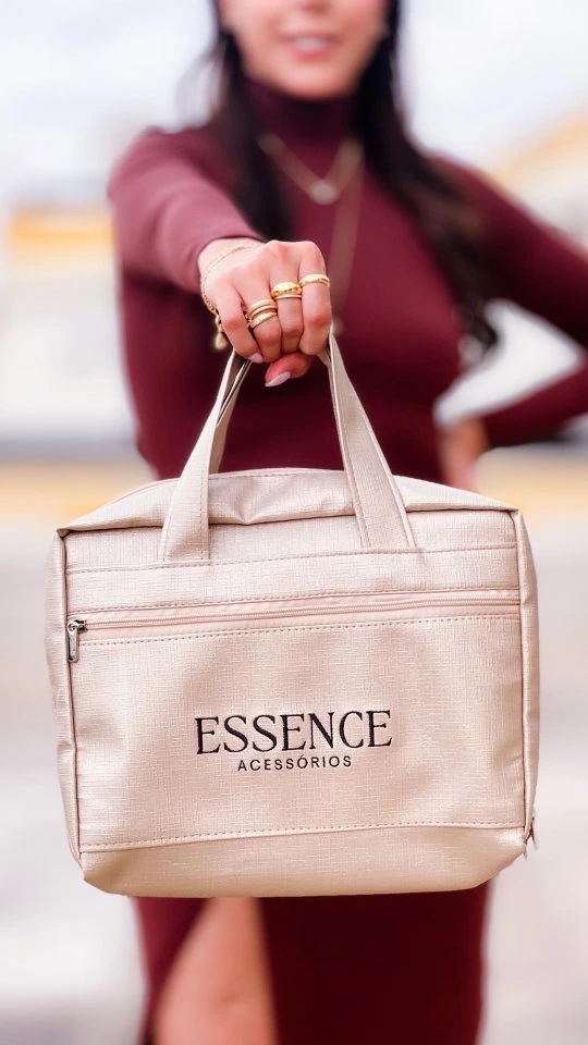 Mulher com semijoias segurando a maleta de revendedora Essence